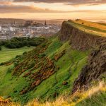 Arthur's Seat rises above Edinburgh in golden light, the destination Florence Pugh calls her eighth wonder of the world.