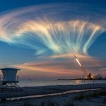 A Falcon 9 rocket launch at dawn creates a glowing jellyfish-shaped exhaust cloud over the US east coast.